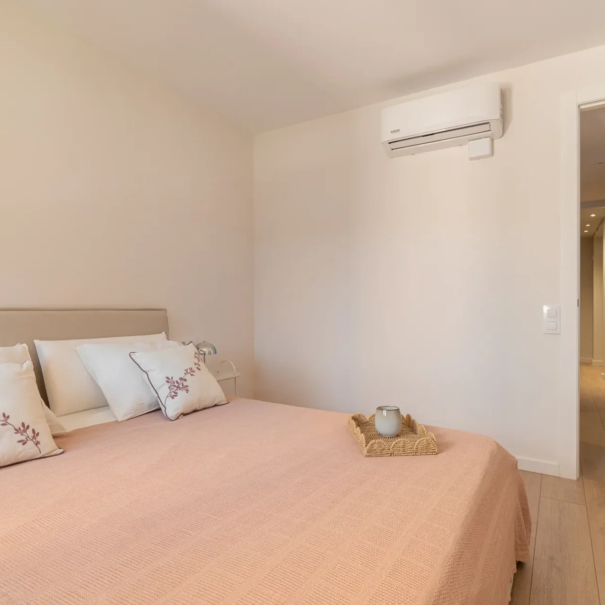 Dormitorio reformado en Sant Andreu, Barcelona, con cama doble y cabecero de madera claro, mesitas de noche modernas y decoración minimalista que optimiza el espacio y la luz natural. Diseño funcional y estético.