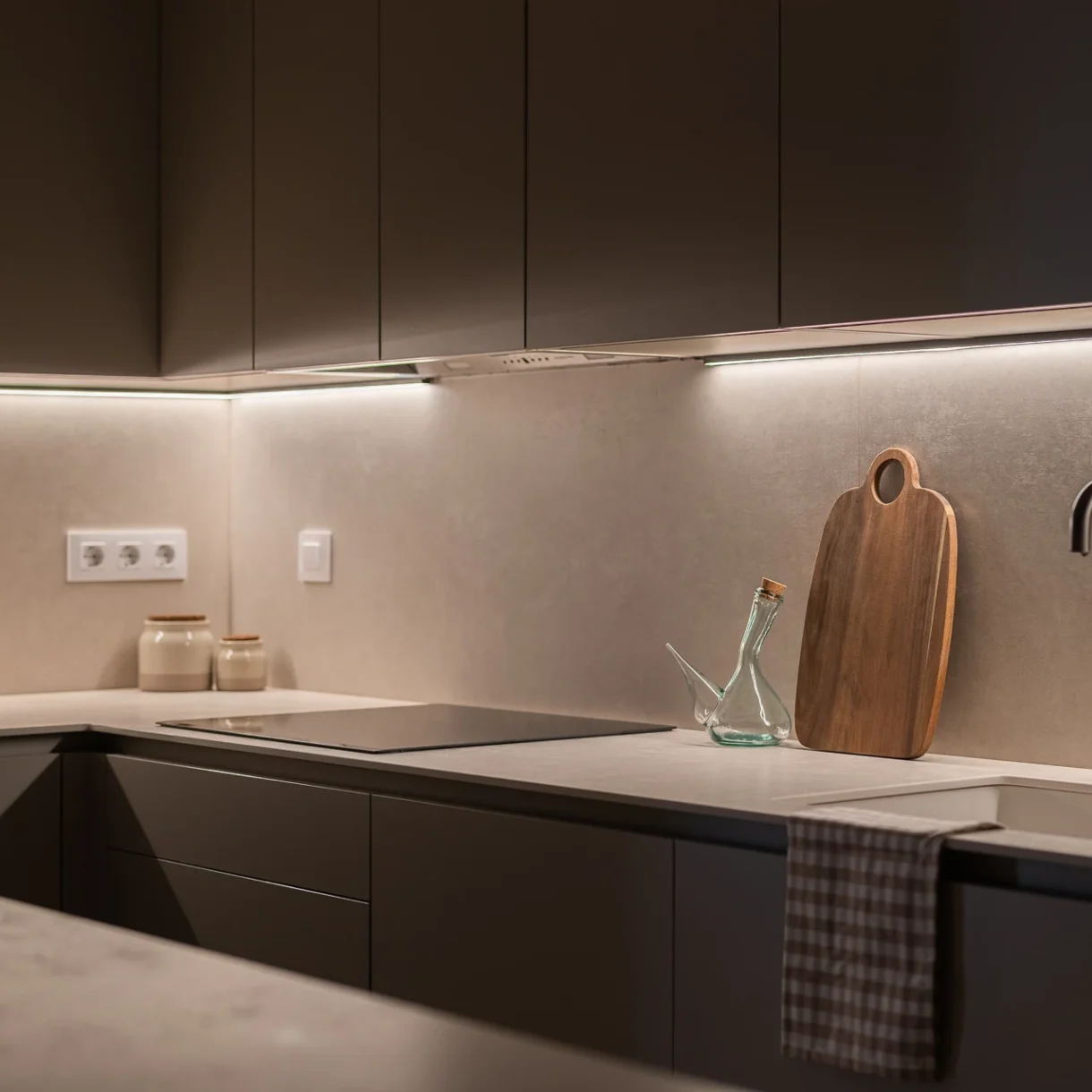 Cocina moderna en tonos neutros con isla central y electrodomésticos integrados, optimizando espacio y diseño en Sant Andreu, Barcelona.