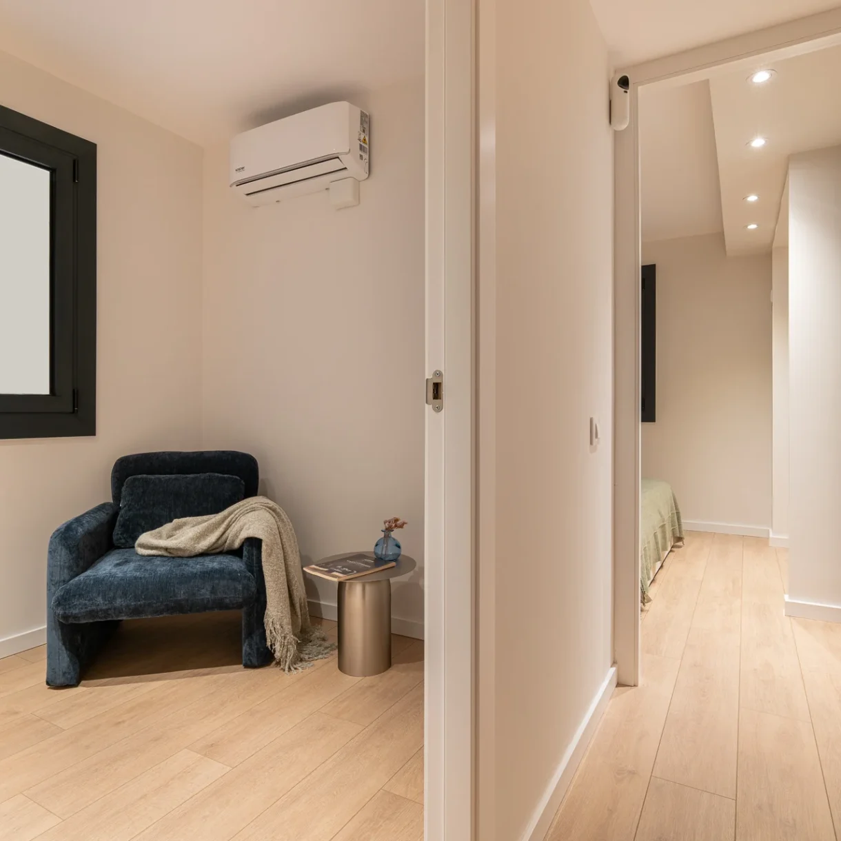 Diseño moderno de habitación reformada en Sant Andreu, Barcelona, con cama doble, decoración minimalista y luz natural.