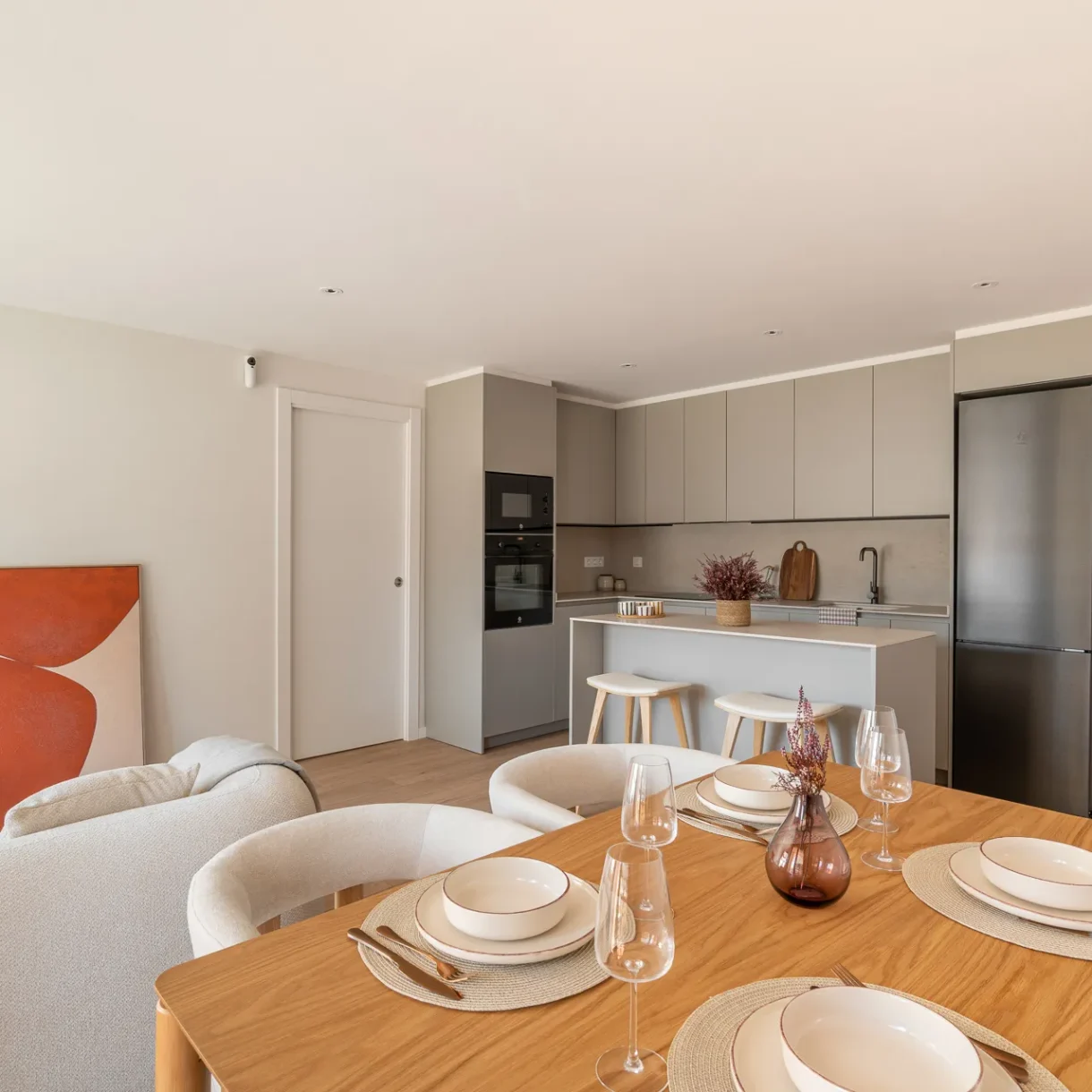 Diseño de interior de un moderno salón comedor con cocina abierta en un proyecto en Sant Andreu, Barcelona, destacando la fluidez espacial.